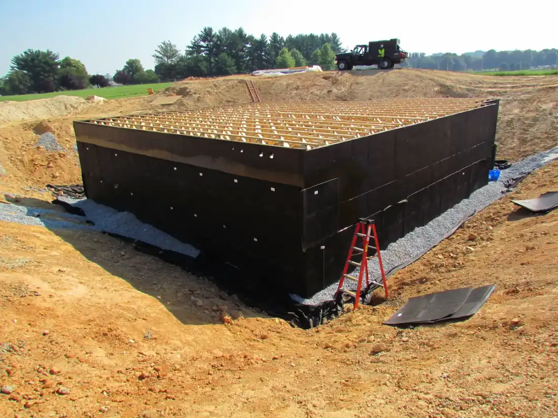 Muro de cimentación protegido con lámina impermeable negra antes del relleno de tierras